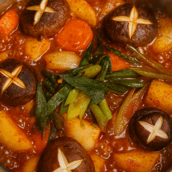 Korean braised chicken stew with potatoes, carrots and scored shiitake mushrooms in a spicy red sauce